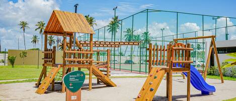 Ein Spielplatz mit Klettergeräten, Rutschen und einer Holzüberdachung.
