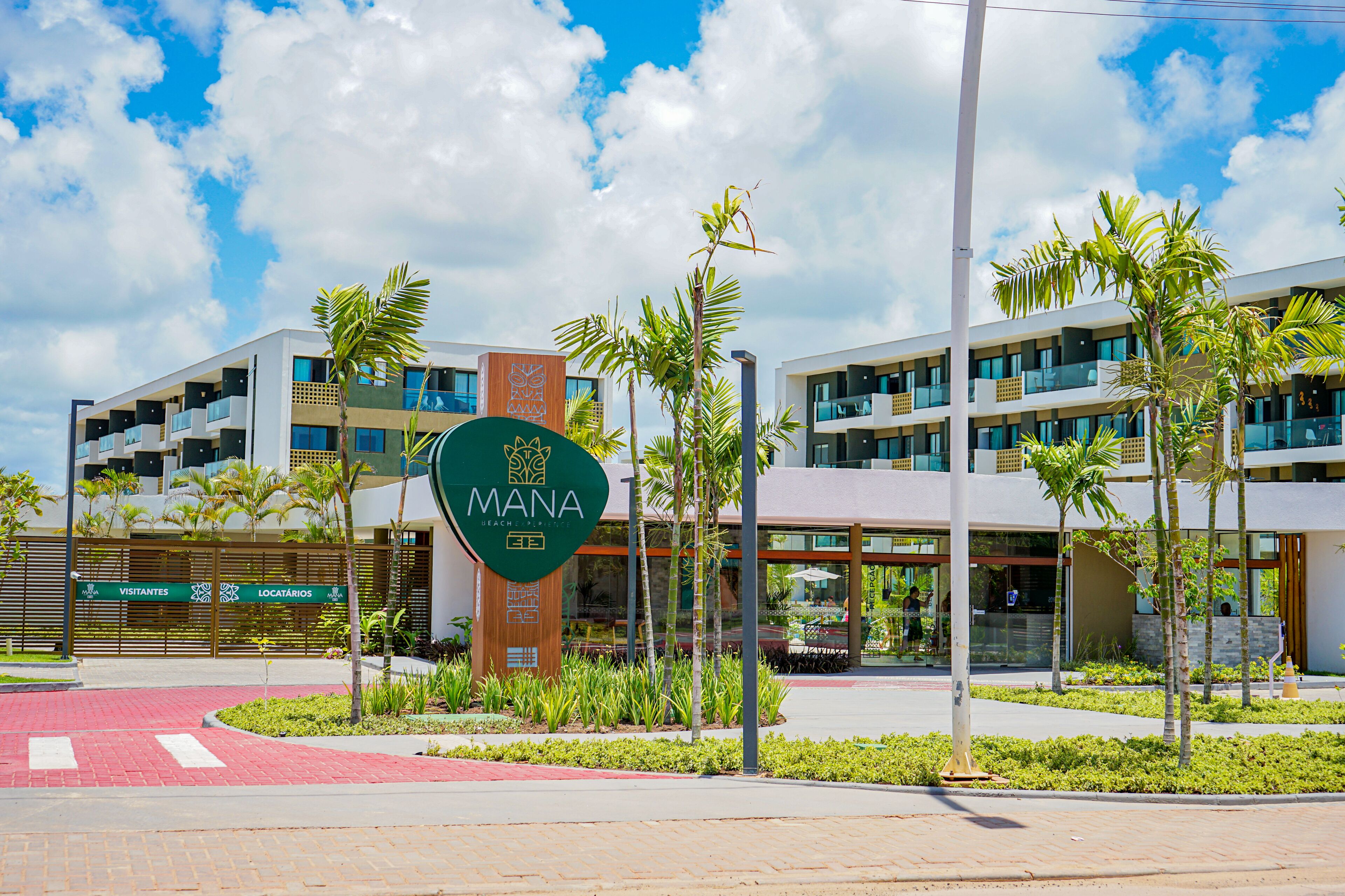 A modern building with a sign reading "MANA Beach Resort".