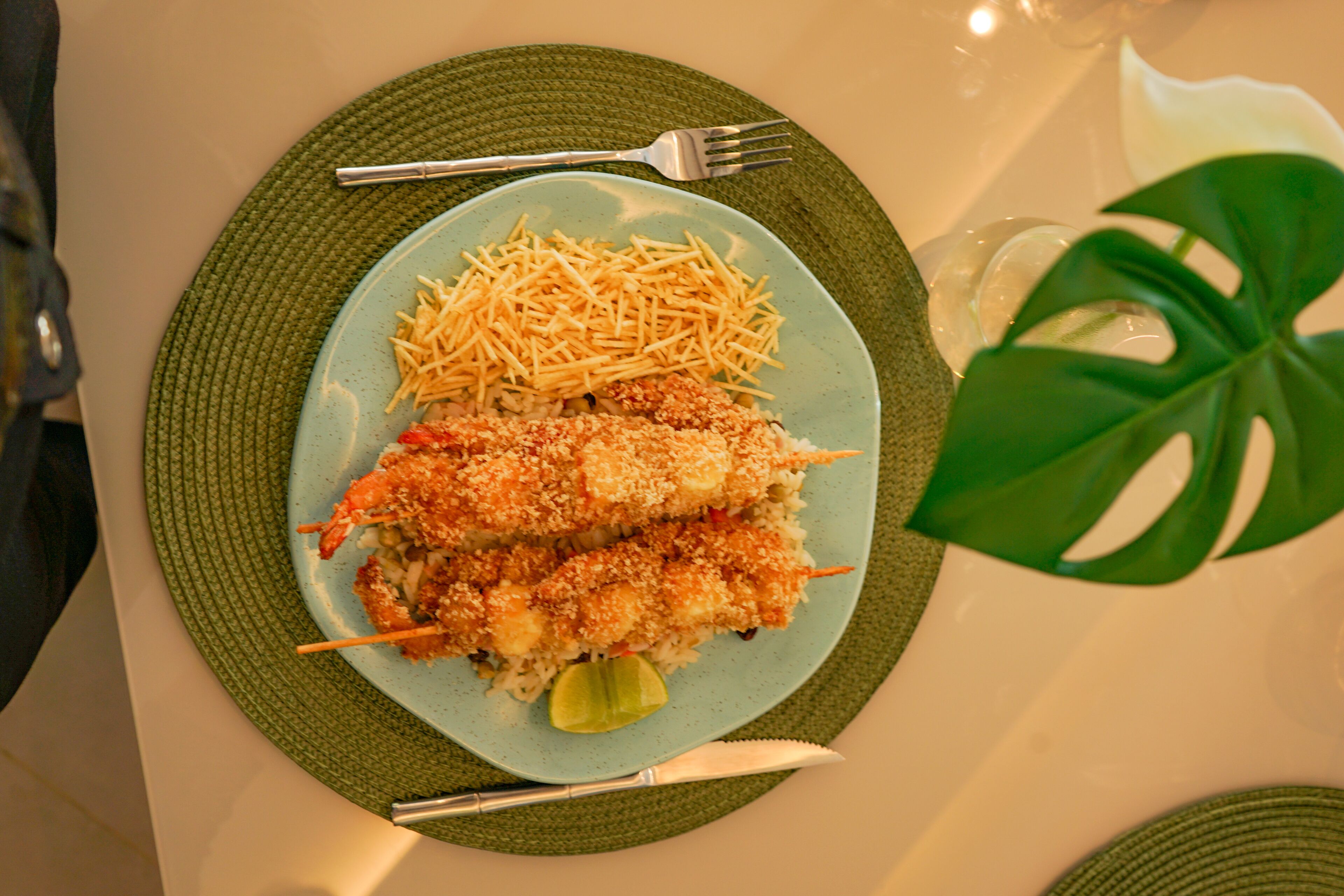 Une assiette de nourriture avec une fourchette et un couteau, posée sur un tapis vert.