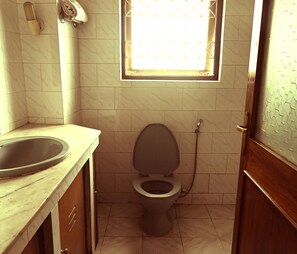 A bathroom with a toilet, a sink, and a window. - Say Xplorica Dechen Villa (Gangtok)