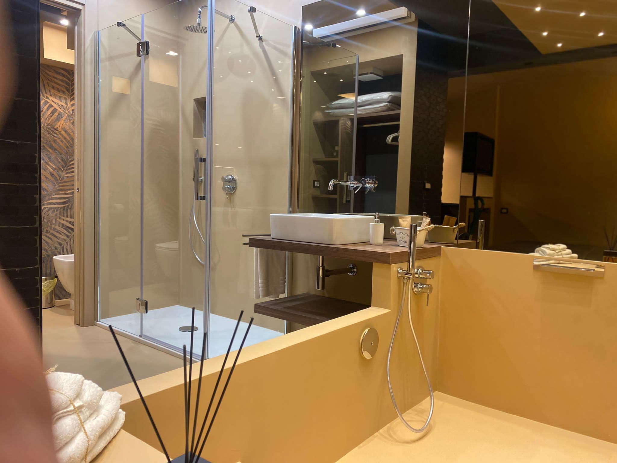 Ein modernes Badezimmer mit einer Duschkabine, einem Waschtisch und einem Spiegel.