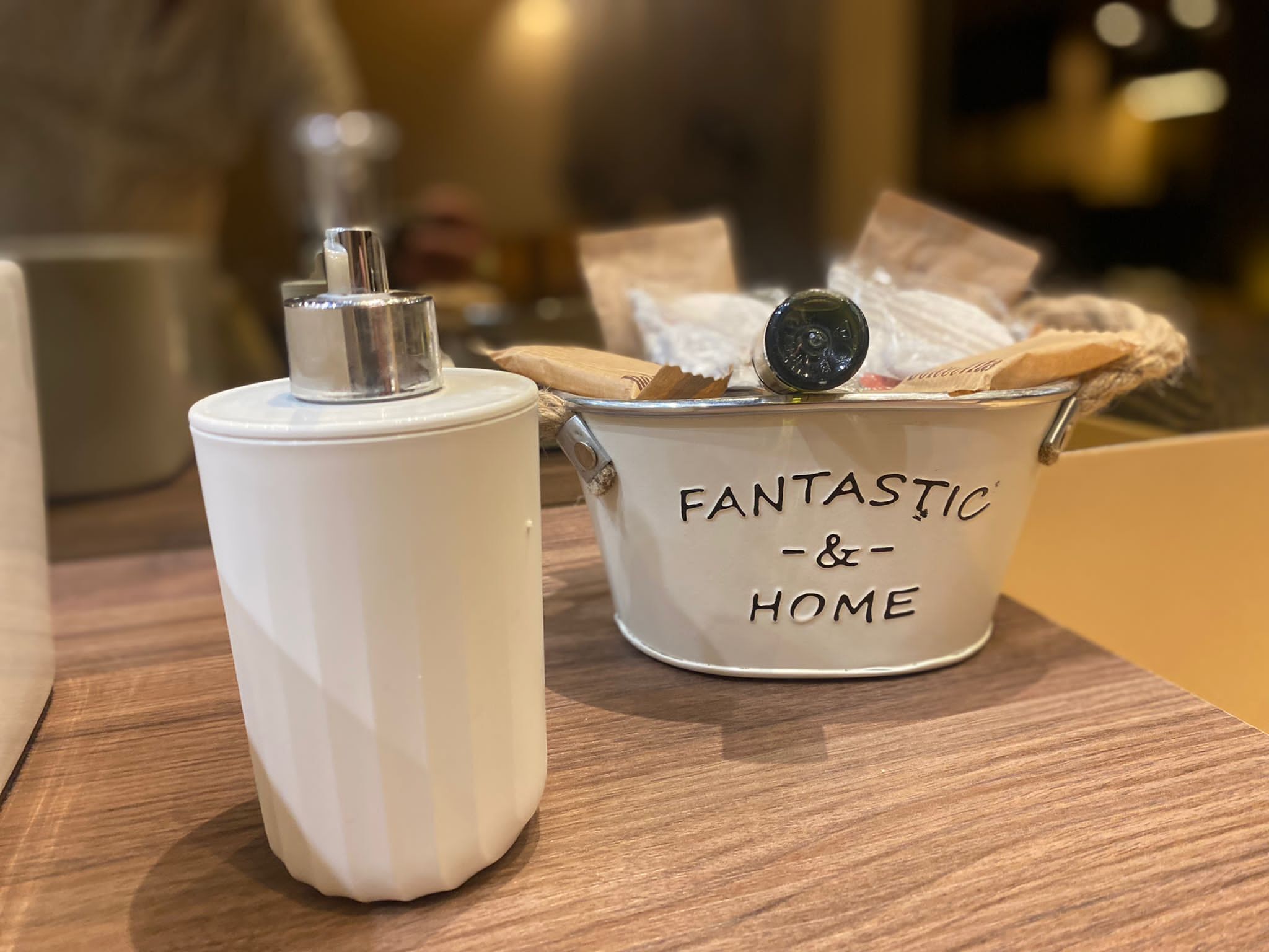 A white container with a lid and a smaller bucket labeled "FANTASTIC & HOME" on a wooden surface.