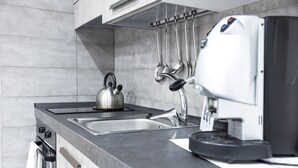 A modern kitchen with a stainless steel sink, a kettle, and a coffee machine. - Montesanto Group  (Naples)