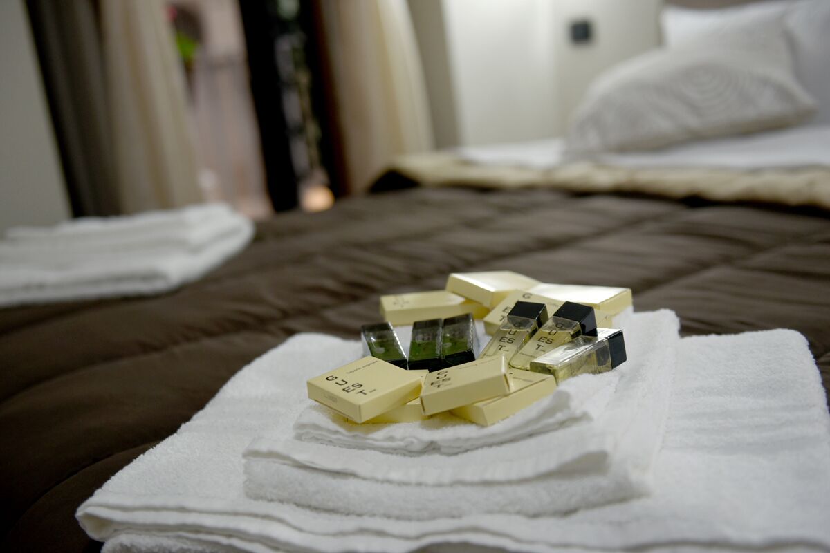 A bed with a brown cover and a white towel on it.