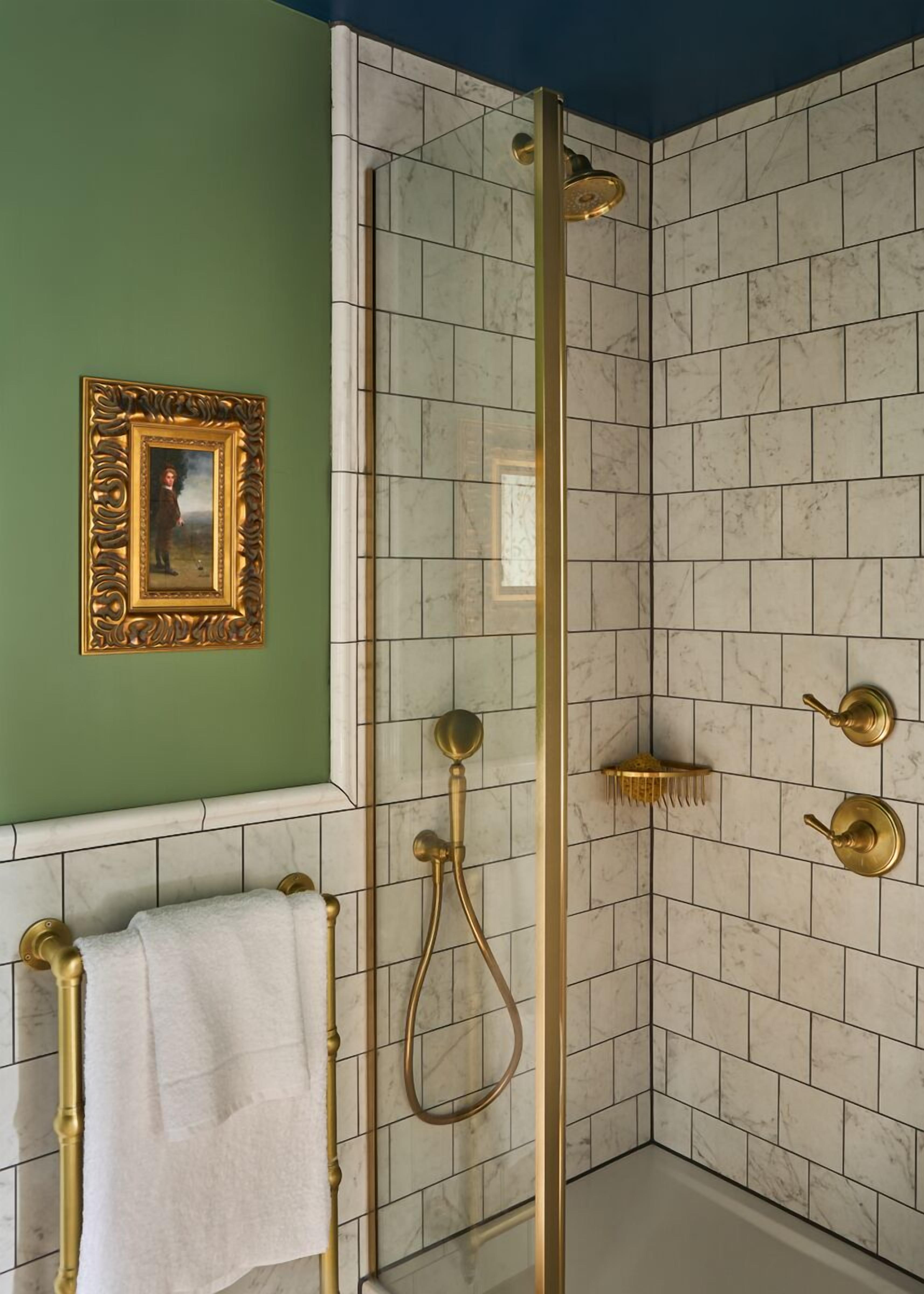 A bathroom with a shower, a towel rack, and a framed picture on the wall.
