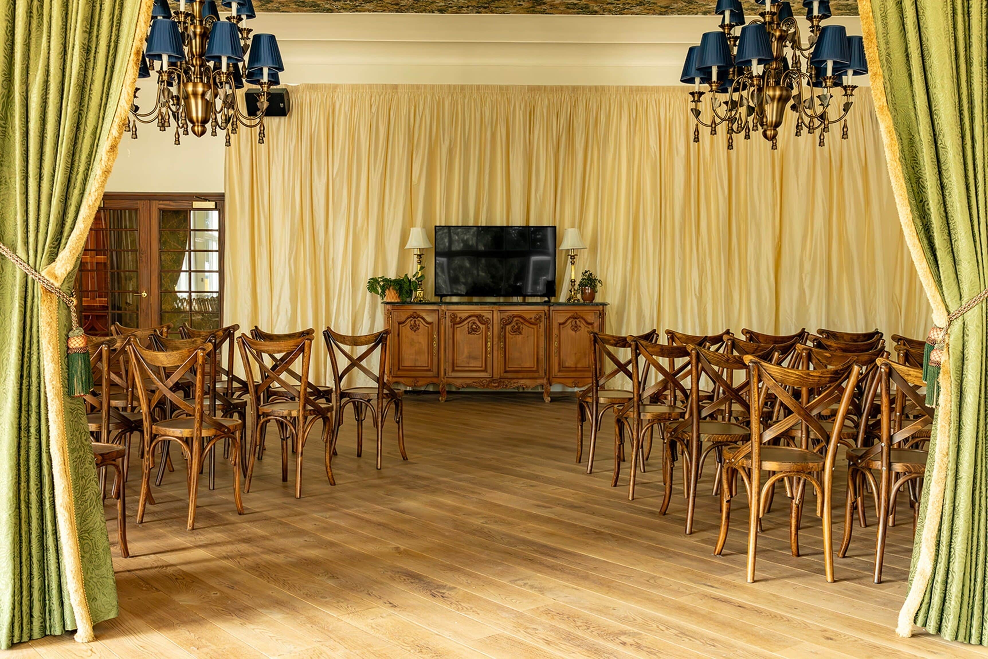 Comedor formal con una alacena de madera, un televisor y varias sillas dispuestas alrededor de una mesa central.