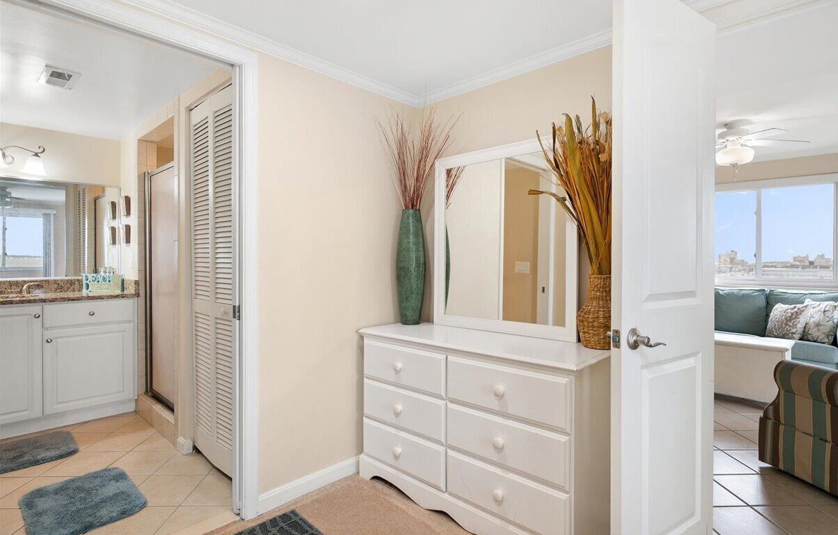 A modern interior with a white dresser, a mirror, and decorative plants.