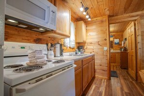 Kitchen features a modern stove, sink, and coffee maker.