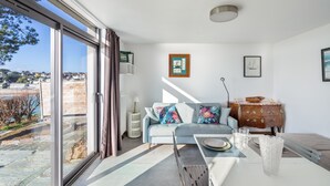 Una sala de estar moderna con un sofá, una mesa de centro y vistas a una masa de agua.