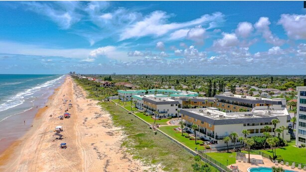 A coastal hotel with multiple buildings, a beach, and a swimming pool. - Well-appointed condo on uncrowded Ormond Beach (Ormond Beach)