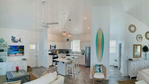 A spacious living area with a kitchen, dining area, and a bedroom with a large bed and a nightstand. - Luxury oceanfront villa 1BR, protected dock, private & gated peninsula (Marsh Harbour)