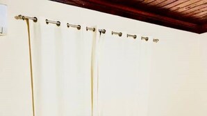 A bedroom with a bed, nightstands, and a white curtain. - Entire Guest Suite - 1 bedroom (Nassau)