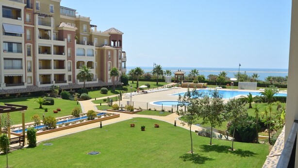 A hotel with a pool area, a beach view, and a well-maintained lawn. - Los Cisnes 77 - Two Bedroom Apartment, Sleeps 5 (Punta del moral)
