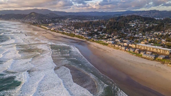 Une ville côtière dotée d’une plage, d’immeubles d’habitation et d’un grand bâtiment à toit plat.