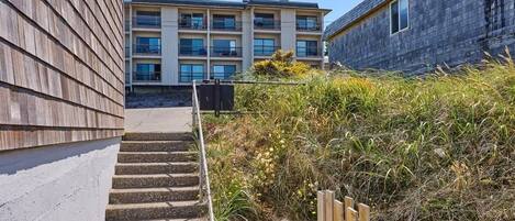 A multi-story building with a staircase leading to a flat entrance area.
