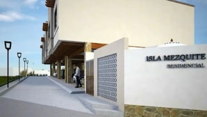 Un edificio moderno con un letrero que dice 'Isla Mezquite Residencial'.