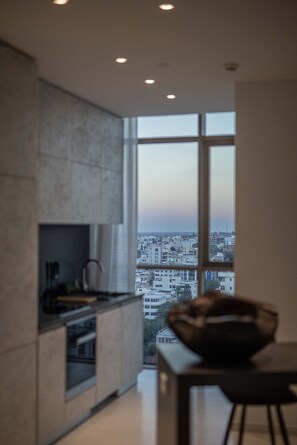 A modern kitchen with a large window overlooking a cityscape. - Saffron Suite | Retreat with Skyline Views & Pool (Nicosia)