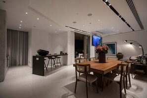 A modern interior with a dining area, kitchen, and living space. - Saffron Suite | Retreat with Skyline Views & Pool (Nicosia)