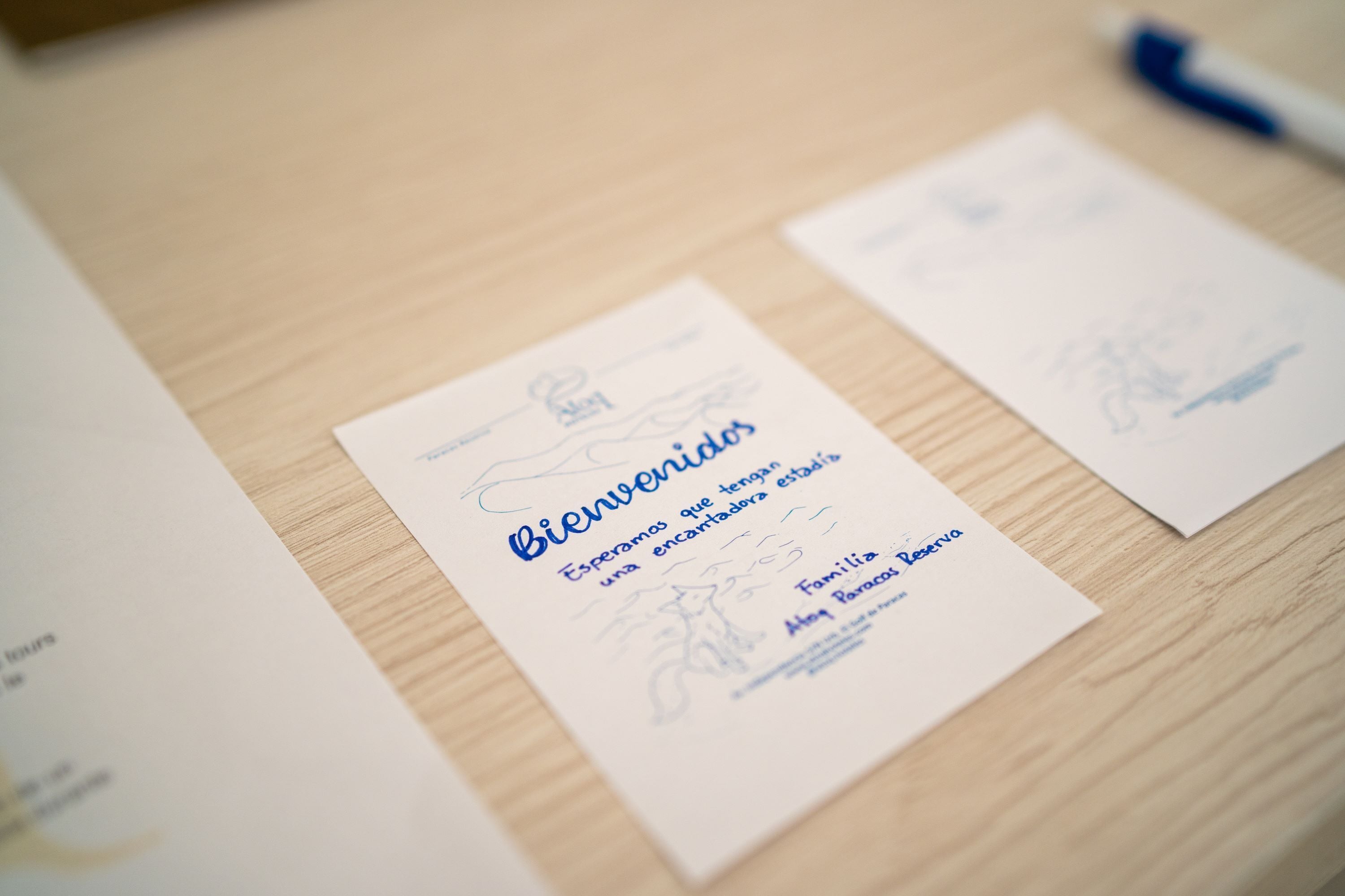 A welcome card with text and a small illustration on a wooden surface.