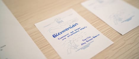 A welcome card with text and a small illustration on a wooden surface.