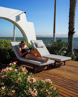 A person relaxing on a sun lounger with a view of the sea. - Atoq Paracas Reserva (Paracas)