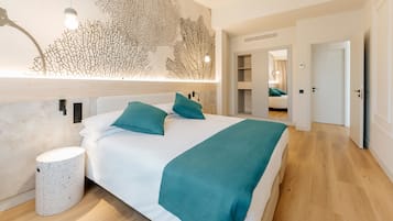 A modern bedroom with a large bed, a wall-mounted light fixture, and a minimalist decor style.