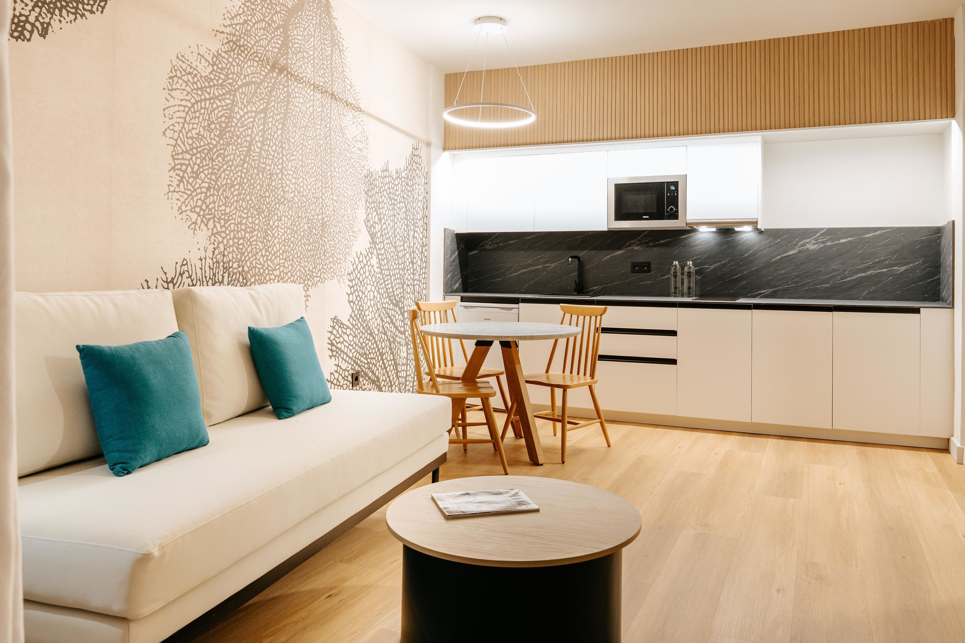 A modern kitchen with a black countertop, wooden cabinets, and a built-in microwave.