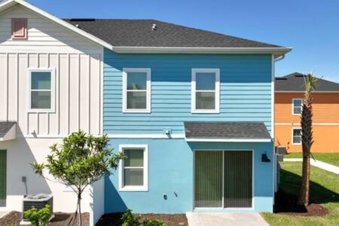 A two-story house with a light blue exterior and white trim.