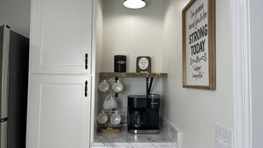 Eine Küche mit weißen Schränken, einer Kaffeemaschine und einem Schild mit der Aufschrift 'Ich brauche dich heute ganz stark.'