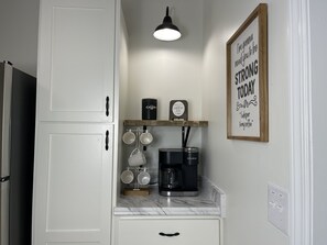 A kitchen with white cabinets, a coffee maker, and a sign that reads "I'm gonna need you to be STRONG TODAY." - NEW w/ King Bed Near Tennis Center & Berry College (Rome)