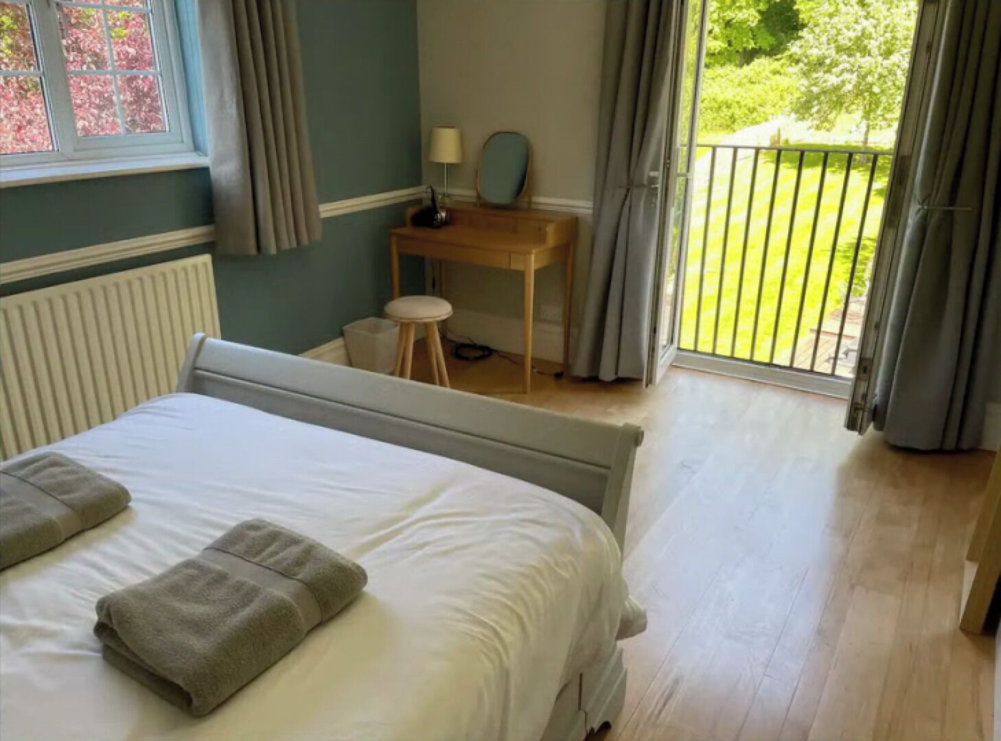 Un dormitorio con cama, escritorio y vistas al exterior.