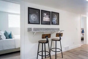 Enjoy casual dining and relaxation in this stylish space with a sofa, bar stools, and artwork.