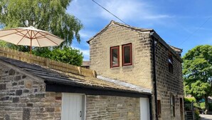 Un bâtiment en pierre avec une porte blanche et une petite fenêtre.