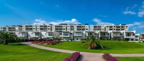 A modern hotel with multiple floors, a central courtyard, and a well-maintained garden.
