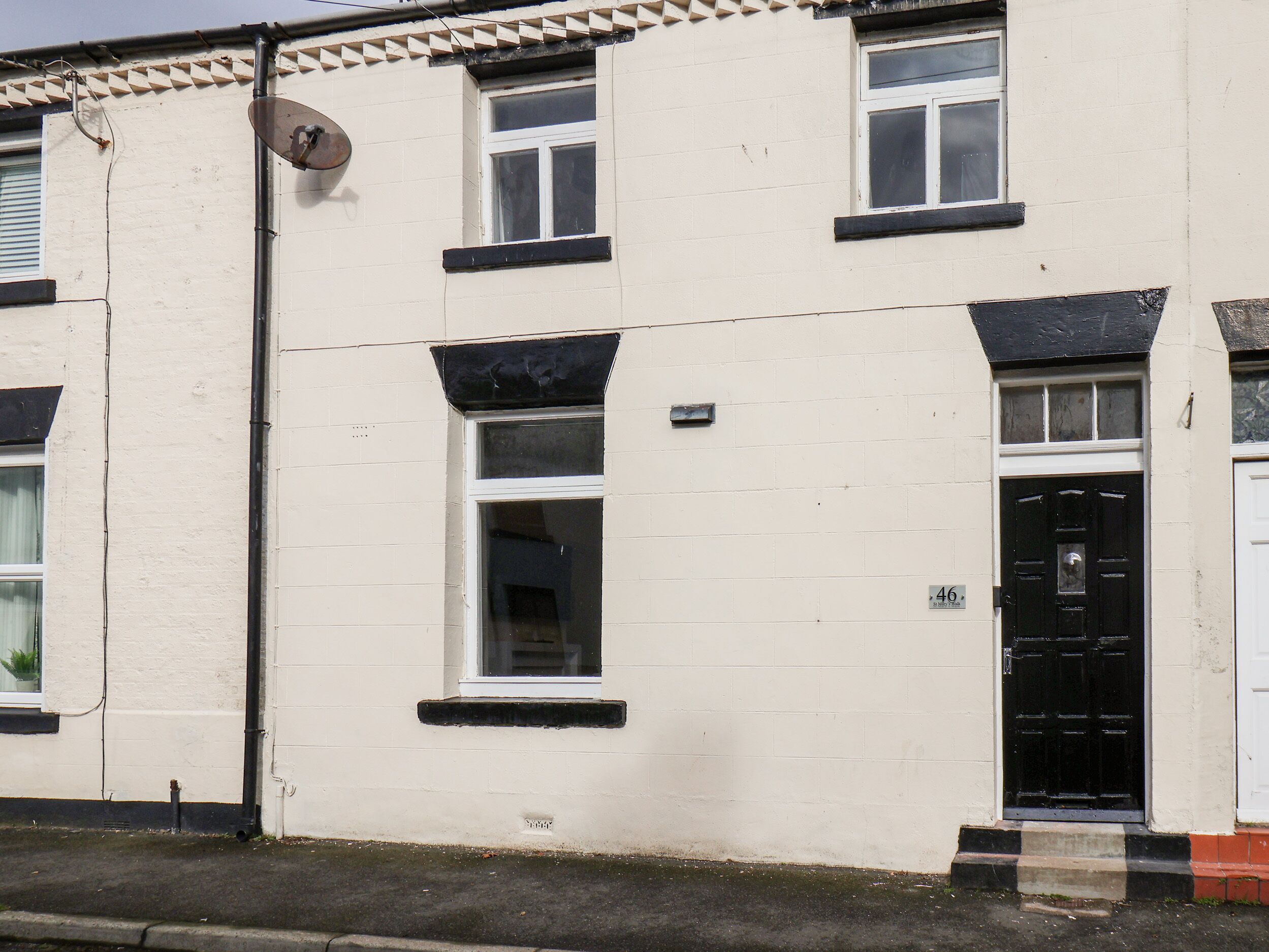 A white building with black-framed windows and a black door.