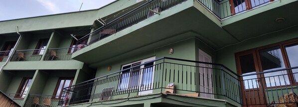 Un edificio a più piani con balconi, ciascuno dotato di ringhiera in metallo.