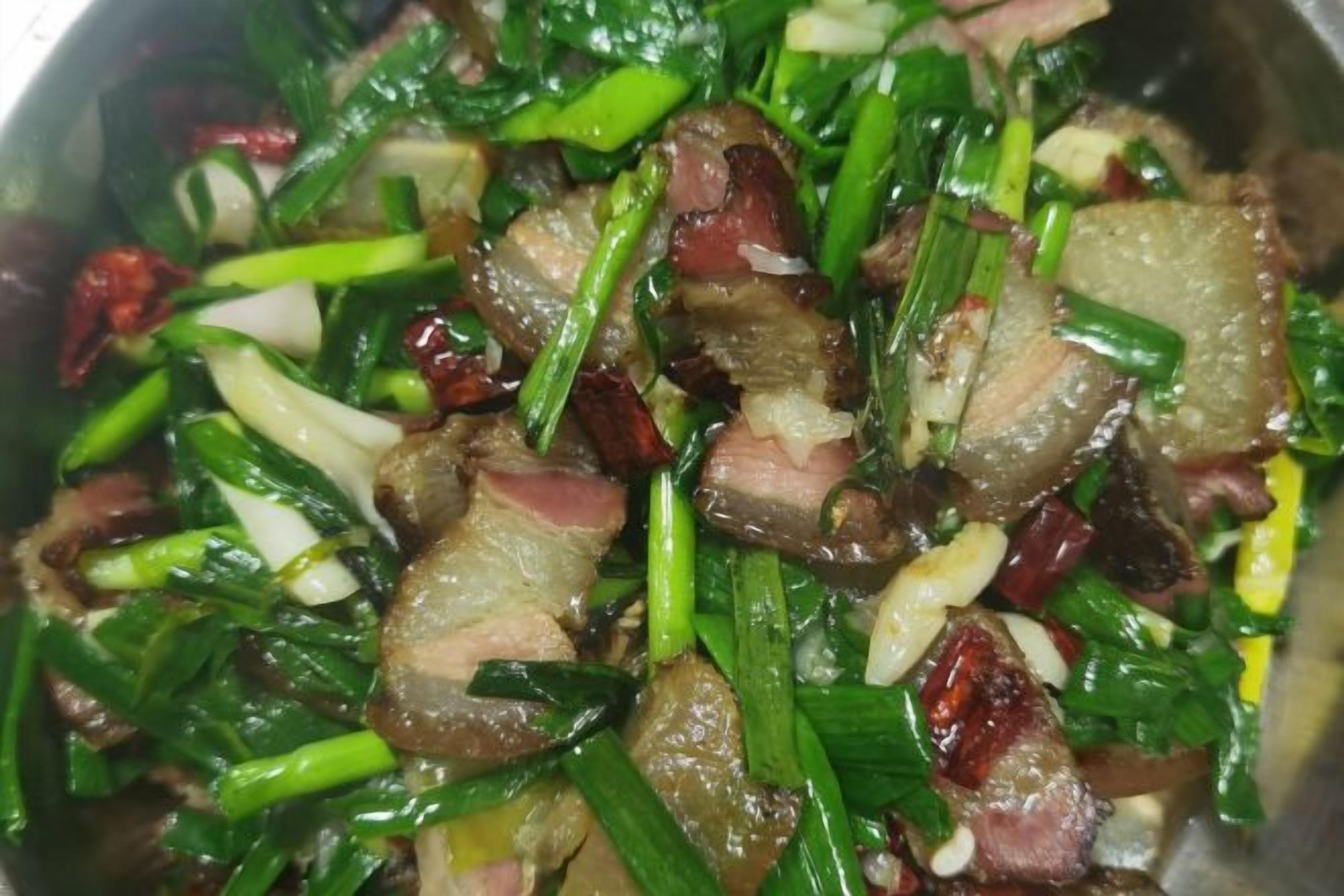 Primer plano de un plato de carne salteada con verduras verdes.