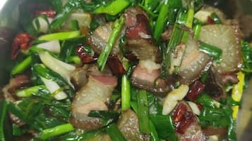 Primer plano de un plato de carne salteada con verduras verdes.