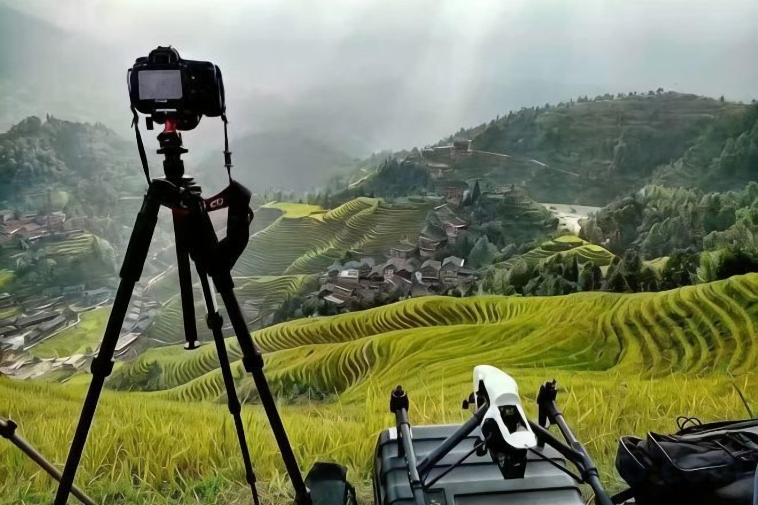 A camera on a tripod overlooking terraced fields.