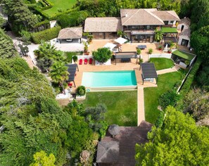 Propiedad residencial con piscina, zona de estar exterior y jardín cuidado.
