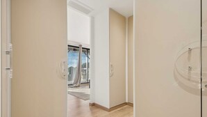 A hallway with a sliding glass door leading to a balcony.