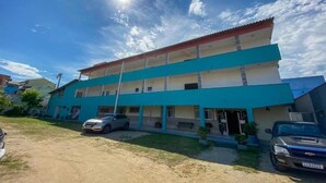 Un immeuble à plusieurs étages, doté d’un toit plat et d’une façade bleue.