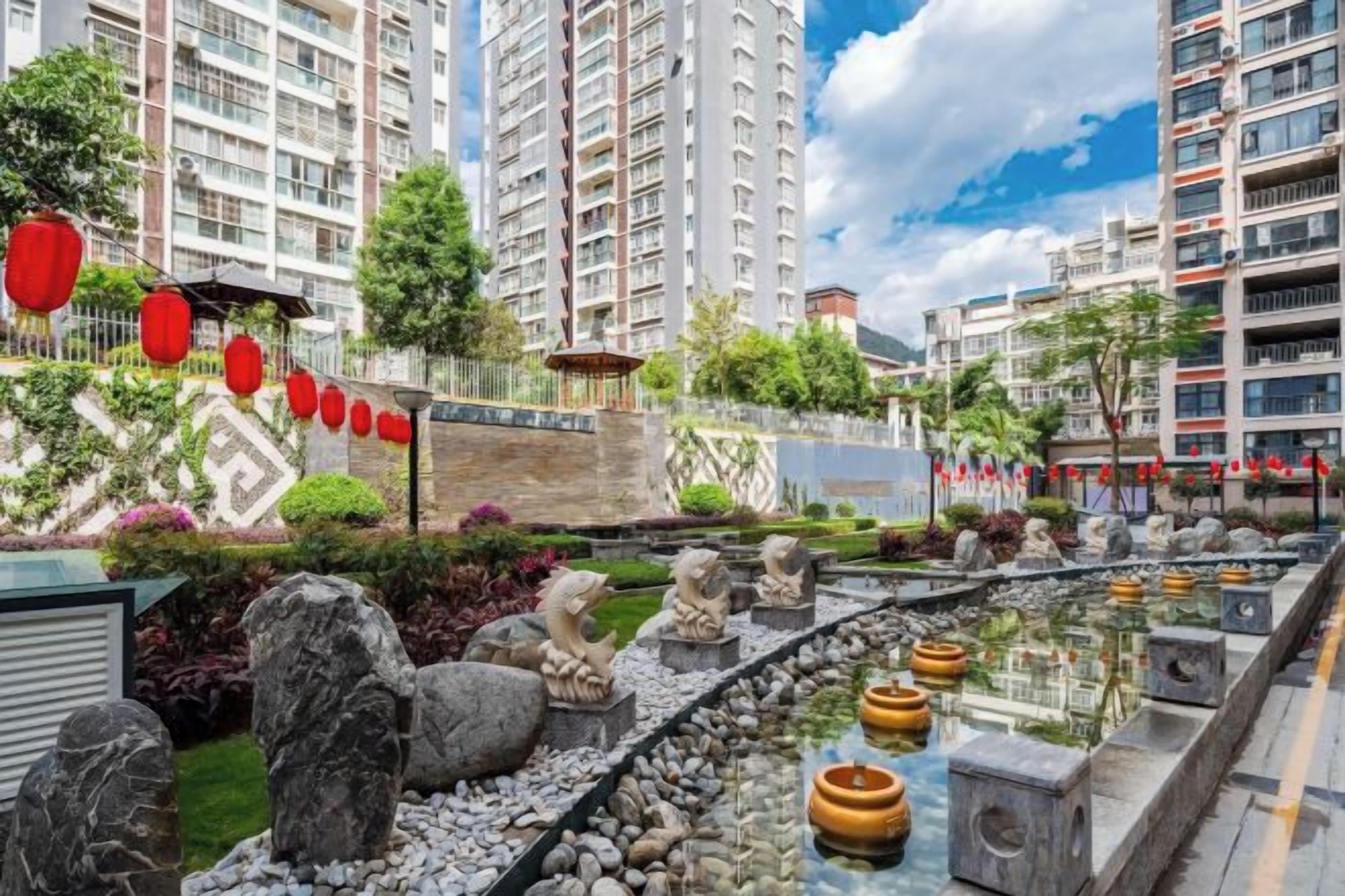 Un jardín ajardinado con fuente, esculturas de piedra y farolillos rojos.