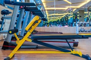 A gym with exercise equipment, including a bench and weights. - Nujiang East Wenhao hotel (Lushui)