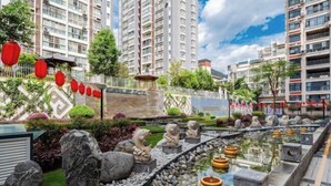 A modern residential complex with high-rise buildings, a koi pond, and decorative stone sculptures. - Nujiang East Wenhao hotel (Lushui)