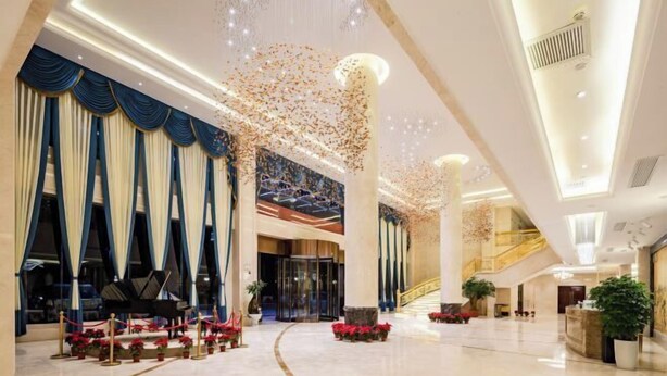 A spacious lobby with a grand piano, a staircase, and a large chandelier. - Nujiang East Wenhao hotel (Lushui)
