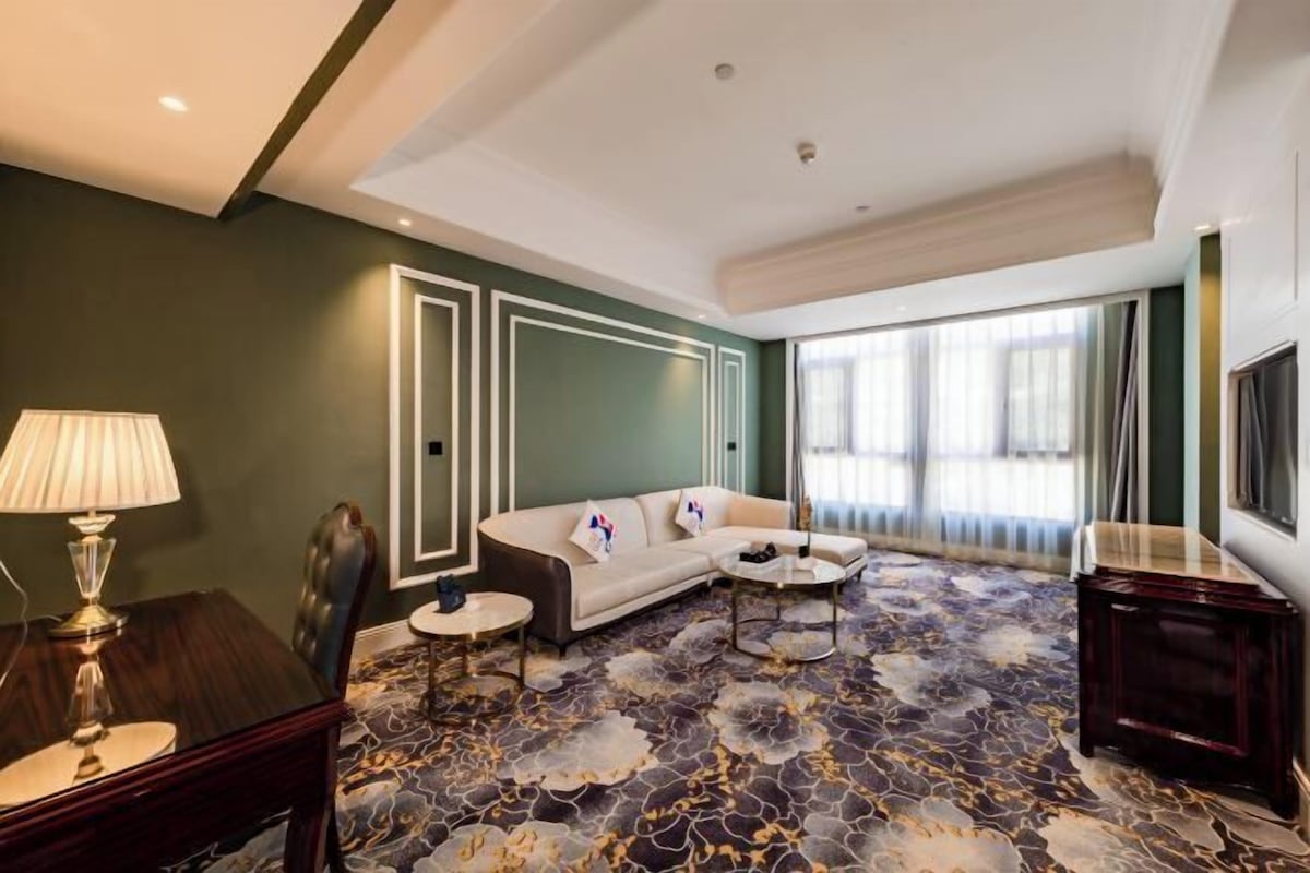 Une chambre d’hôtel moderne, équipée d’un canapé, d’une table basse et d’un téléviseur.