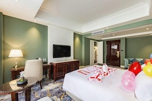 Une chambre d’hôtel équipée d’un lit, d’une télévision, d’un bureau, d’une chaise et d’une lampe.