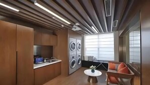 A modern kitchen with built-in appliances, a dining area with a round table, and a sofa. - Home Inn Yubai Yun Hotel (Zhangjiagang Jingang Central Plaza) (Zhangjiagang)