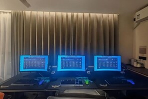 A room with three computer monitors, a desk, and a window with curtains. - Home Inn Yubai Yun Hotel (Zhangjiagang Jingang Central Plaza) (Zhangjiagang)